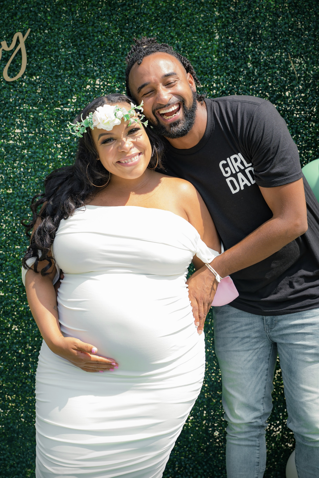 Pregnant Black mom and dad pose at baby shower. 